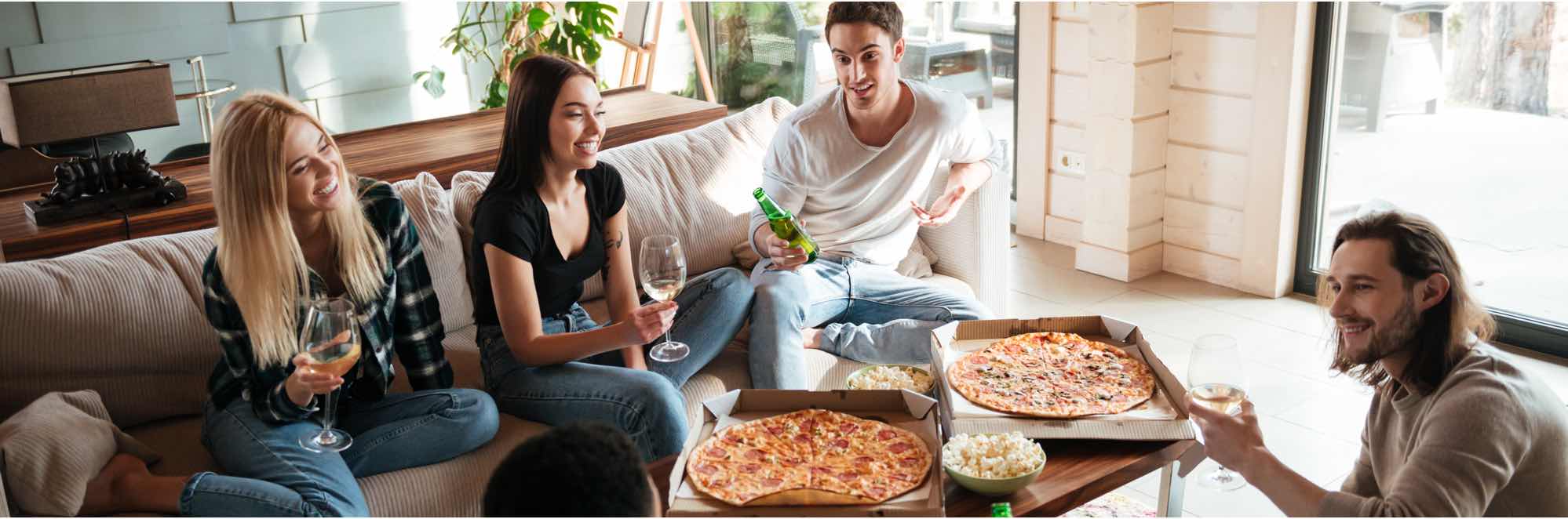 Four people sitting around a table eating pizza